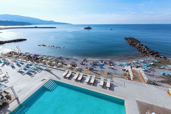 Playa privada, playa de arena negra, camastros y sombrillas 