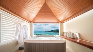 A hot tub in a room with wooden ceiling and a view of the sea. - Pinnacles (Airlie Beach)