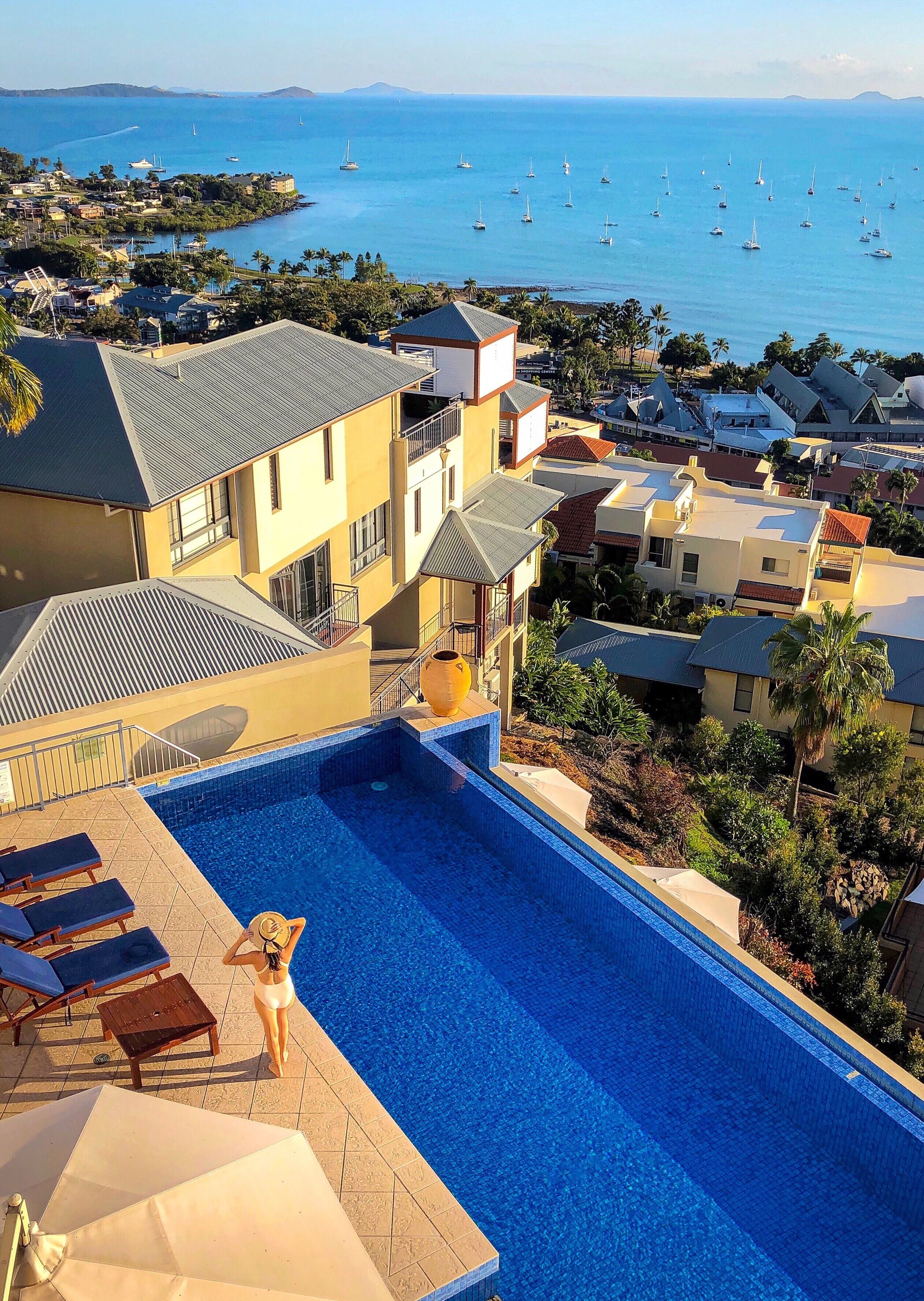 Una piscina con vista al mar y barcos.