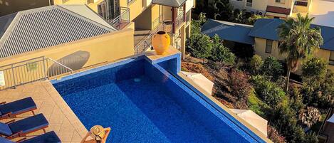 Una piscina con vista al mar y barcos.