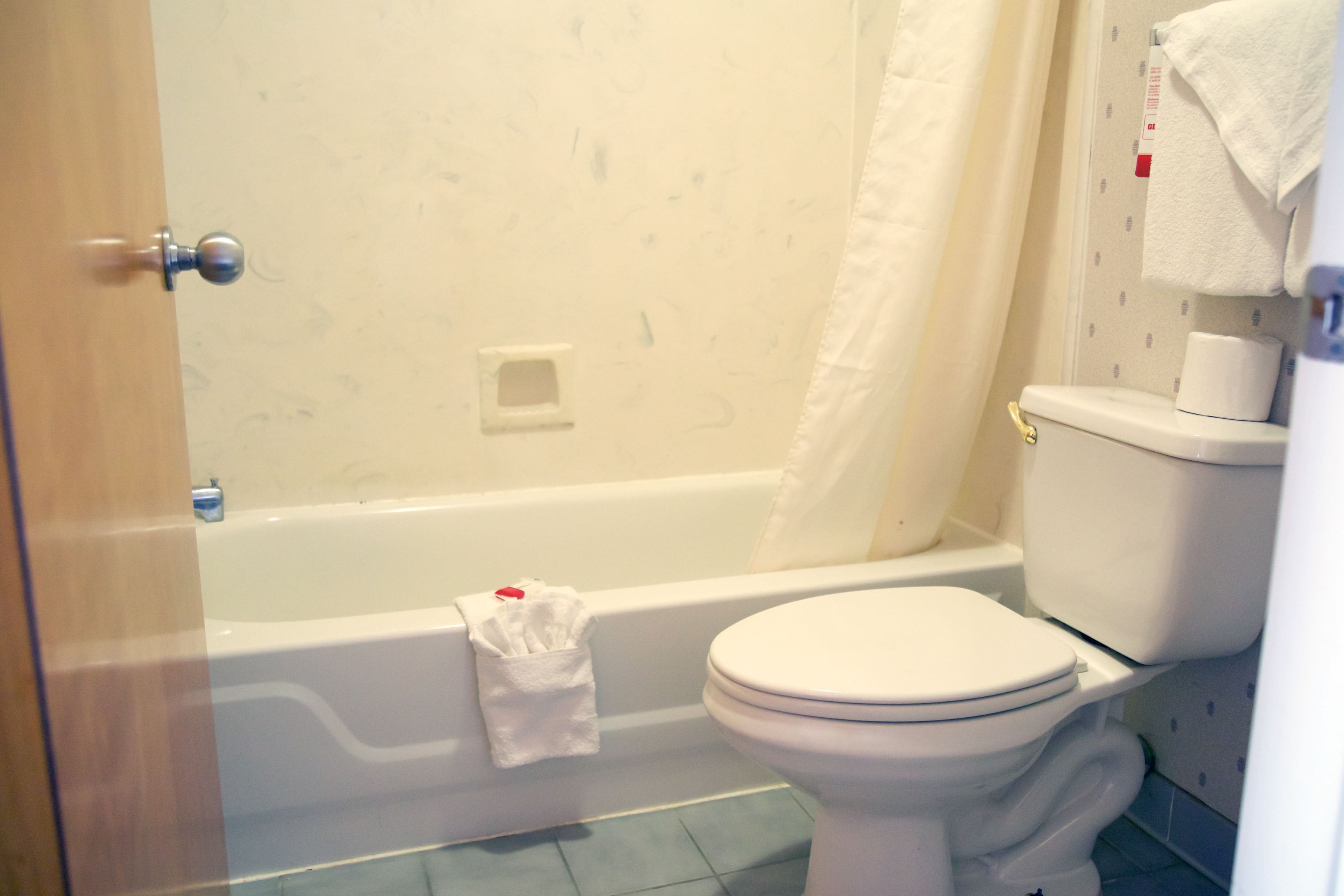 Une salle de bain avec une baignoire, des toilettes et un rideau de douche.