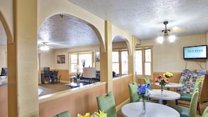 A hotel lobby with a reception desk, seating area, and a television displaying 'TAX10000'. - Super 8 by Wyndham Christiansburg (Christiansburg)
