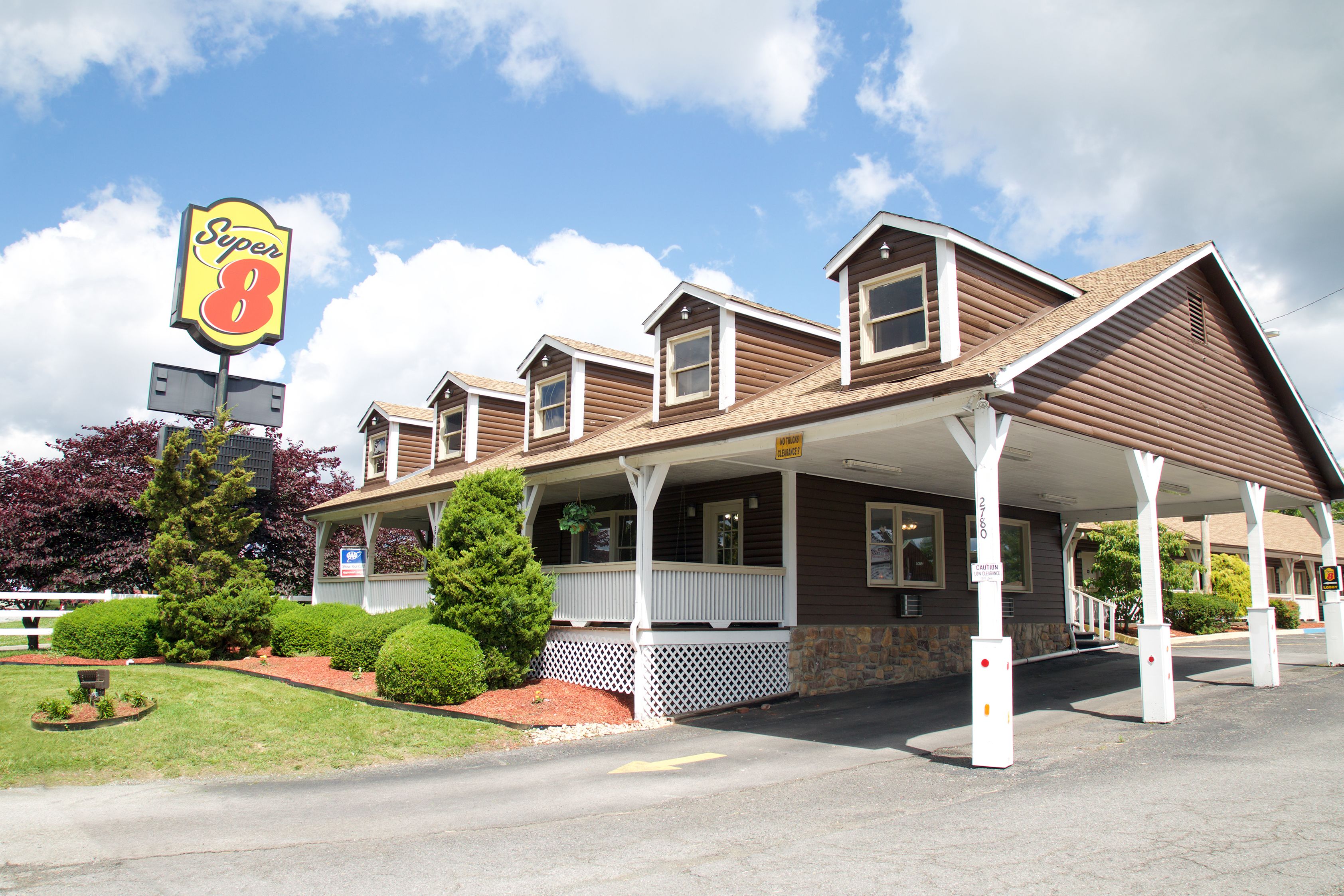 A motel with a covered front porch, a sign reading "Super 8", and a parking lot.