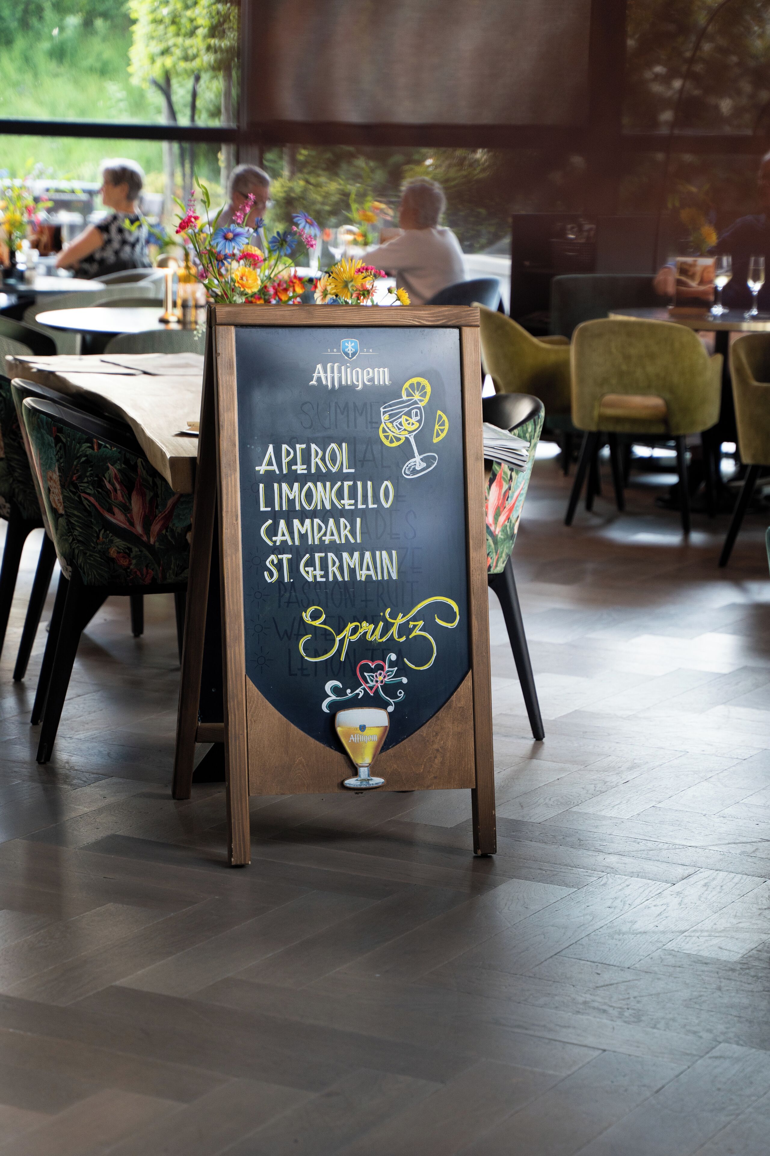 Een krijtbord menukaart met een lijst drankjes en een specialiteit.