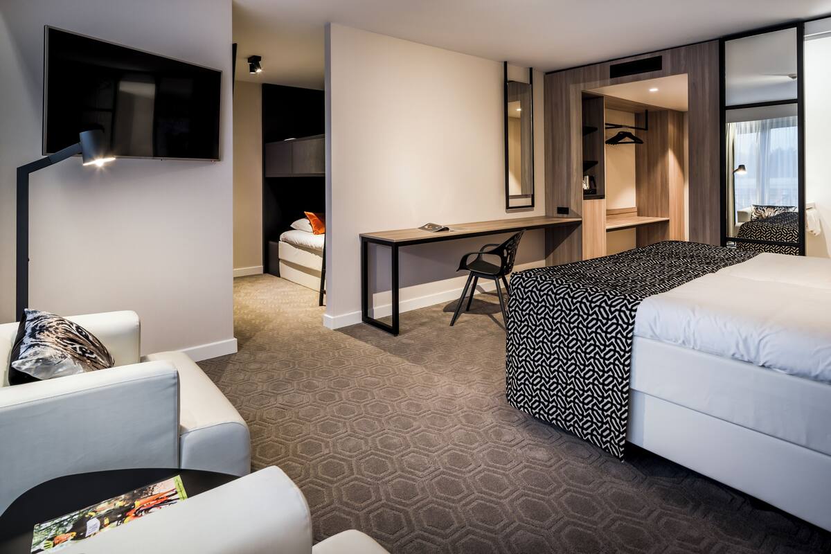 Familiekamer (Deluxe) | Luxe beddengoed, donsdekens, een minibar, een kluis op de kamer