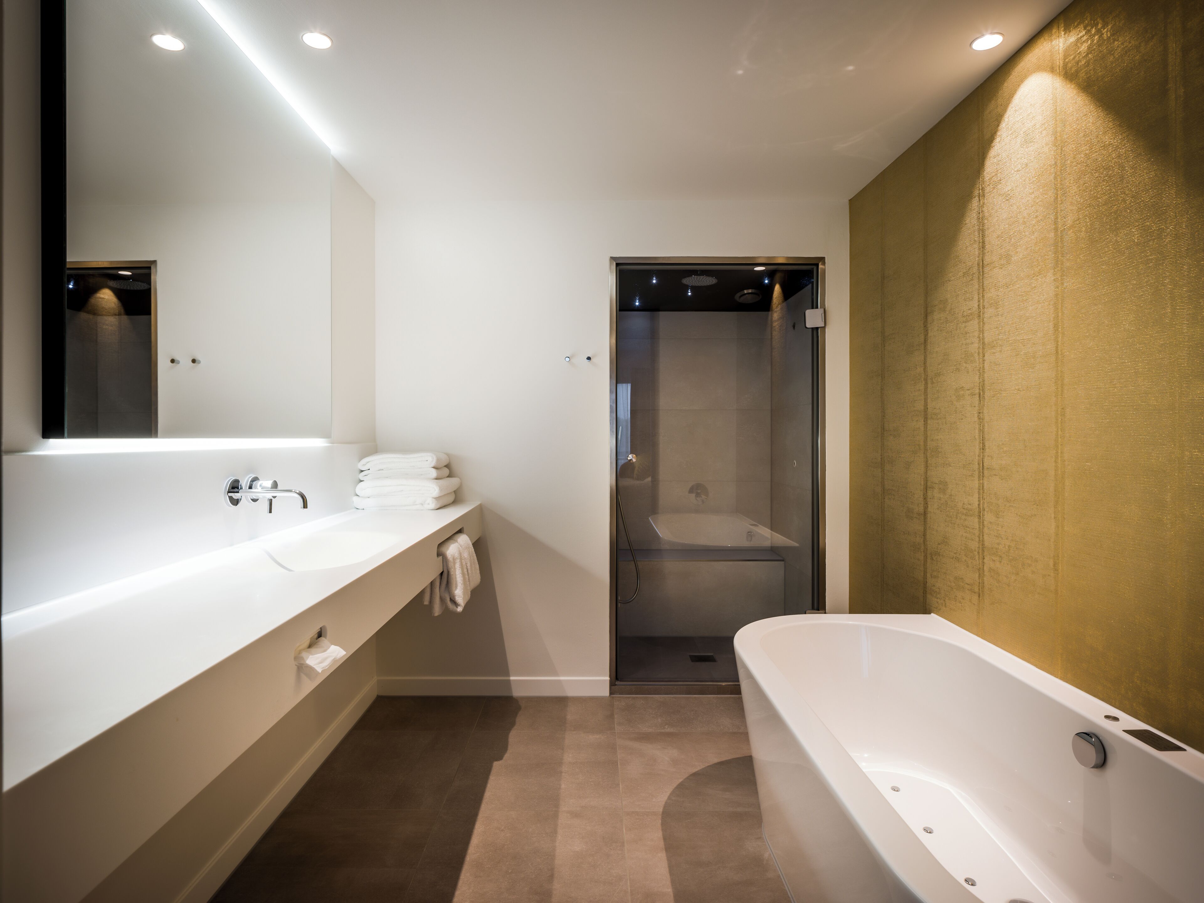 Une salle de bain moderne avec une grande baignoire blanche, un meuble-lavabo avec un miroir et un espace douche.