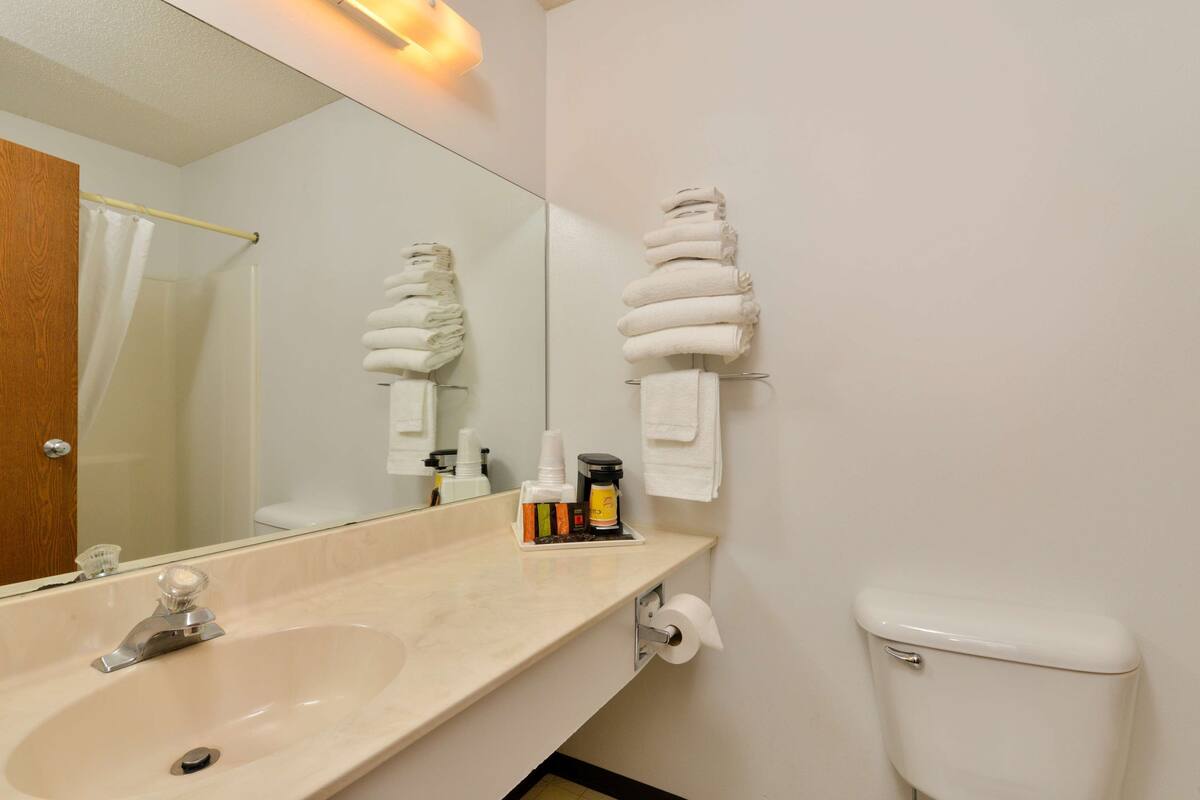 A bathroom with a sink, toilet, and towel rack.