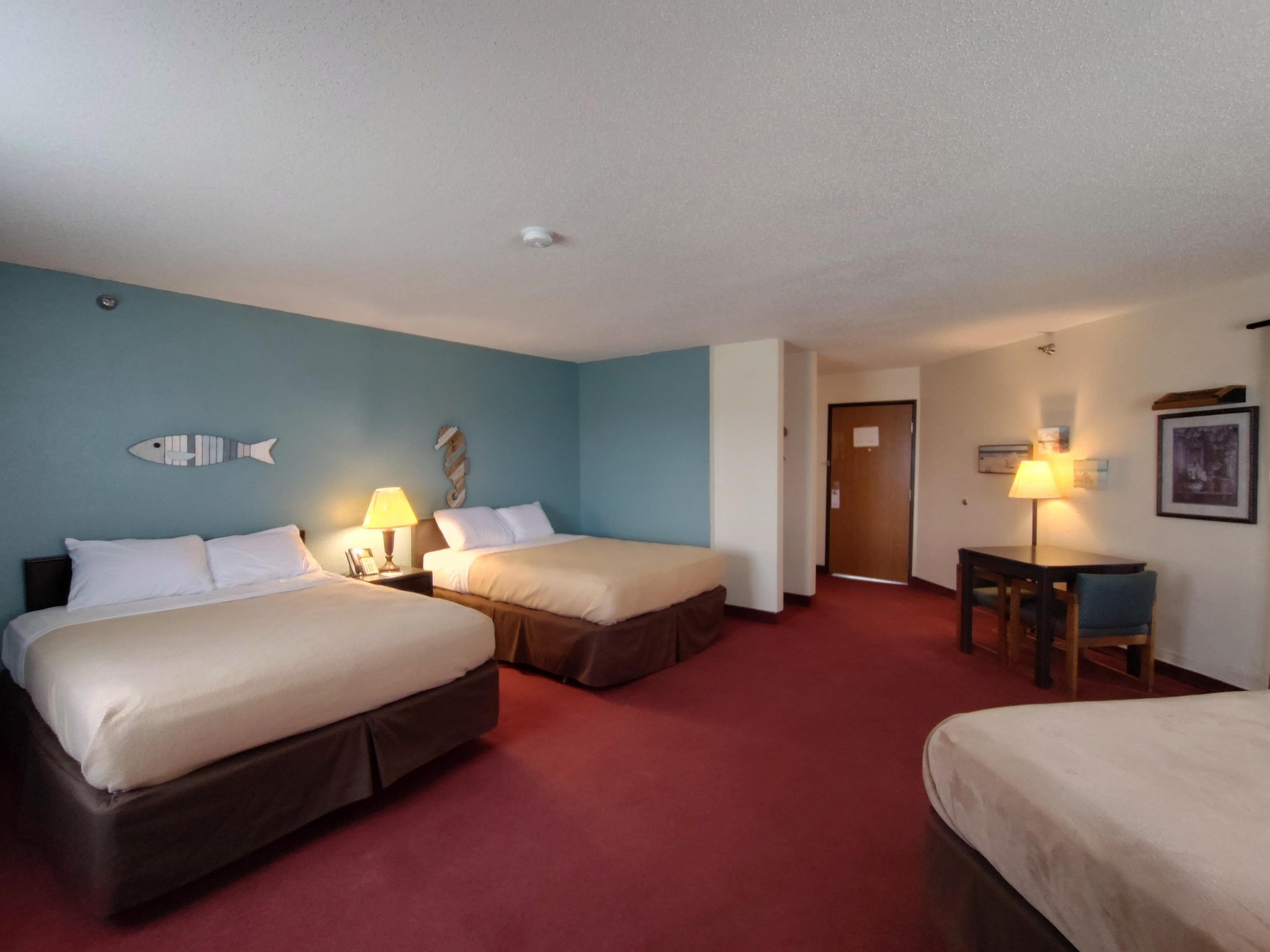 Una habitación de hotel con dos camas, un escritorio y una silla.