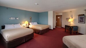 A hotel room with two beds, a desk, and a chair.