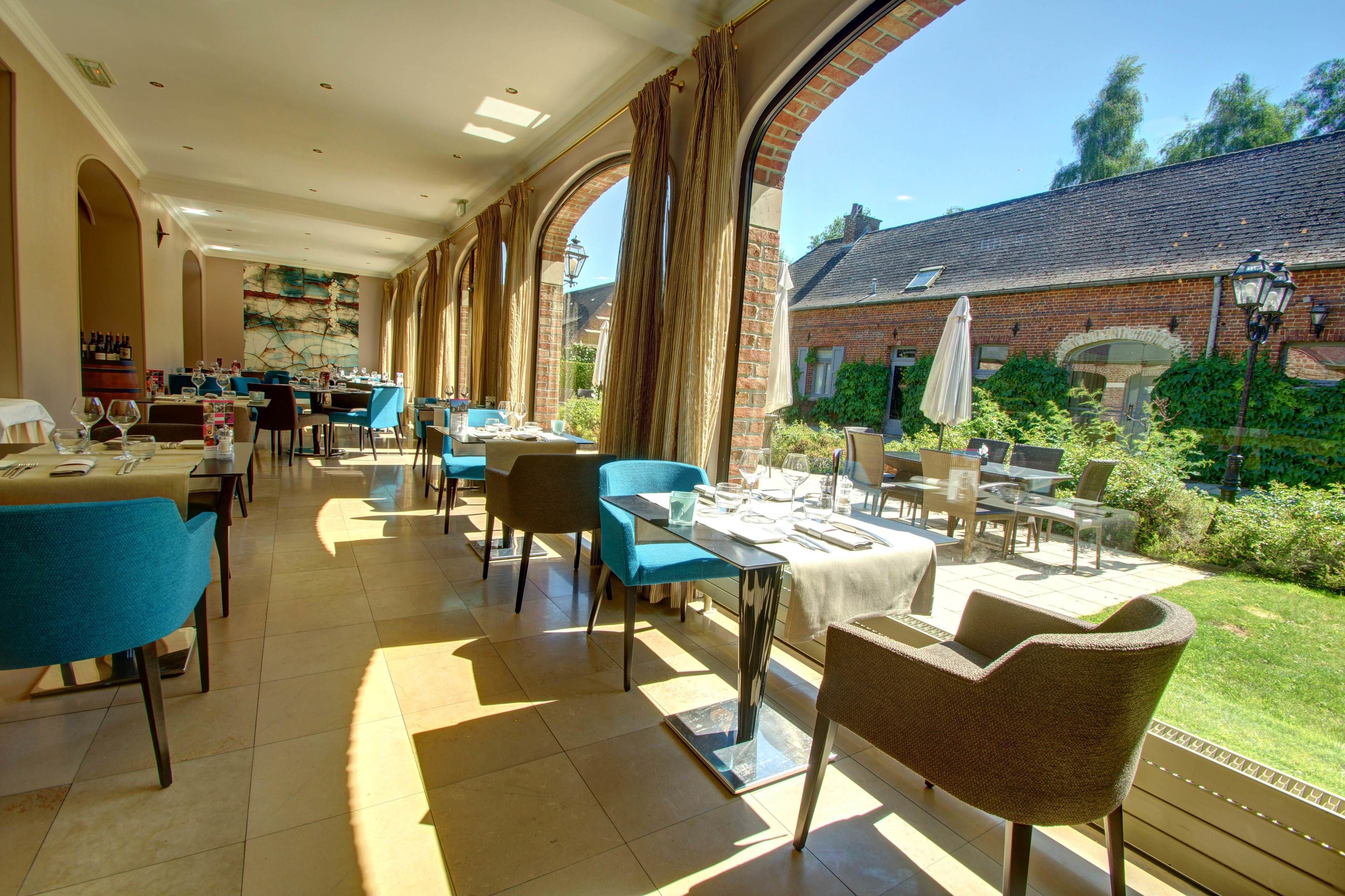 Ein Restaurant mit Außenbereich, Backsteinwänden und Blick auf den Garten.