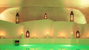 Piscina com iluminação verde e vários lanternas ao longo das paredes.