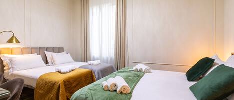 A hotel room with two beds, a desk, and a chair.