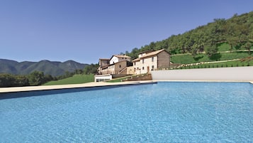 Una piscina al aire libre de temporada, sombrillas