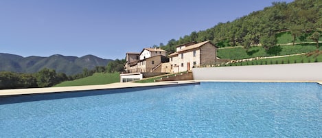 Una piscina al aire libre de temporada, sombrillas