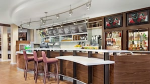 Eine moderne Bar mit einer Holztresen, Barhocker und einer Speisekarte.