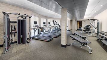 A modern gym with treadmills, weight machines, and benches.