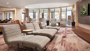 Ein stilvoller Lounge-Bereich mit Ecksofa, Sessel und einem gemusterten Teppich.