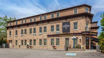 Un bâtiment historique en briques, sur lequel on peut lire l’enseigne « The Parlor Inn & Suites ».
