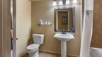 A bathroom with a toilet, sink, and shower curtain.
