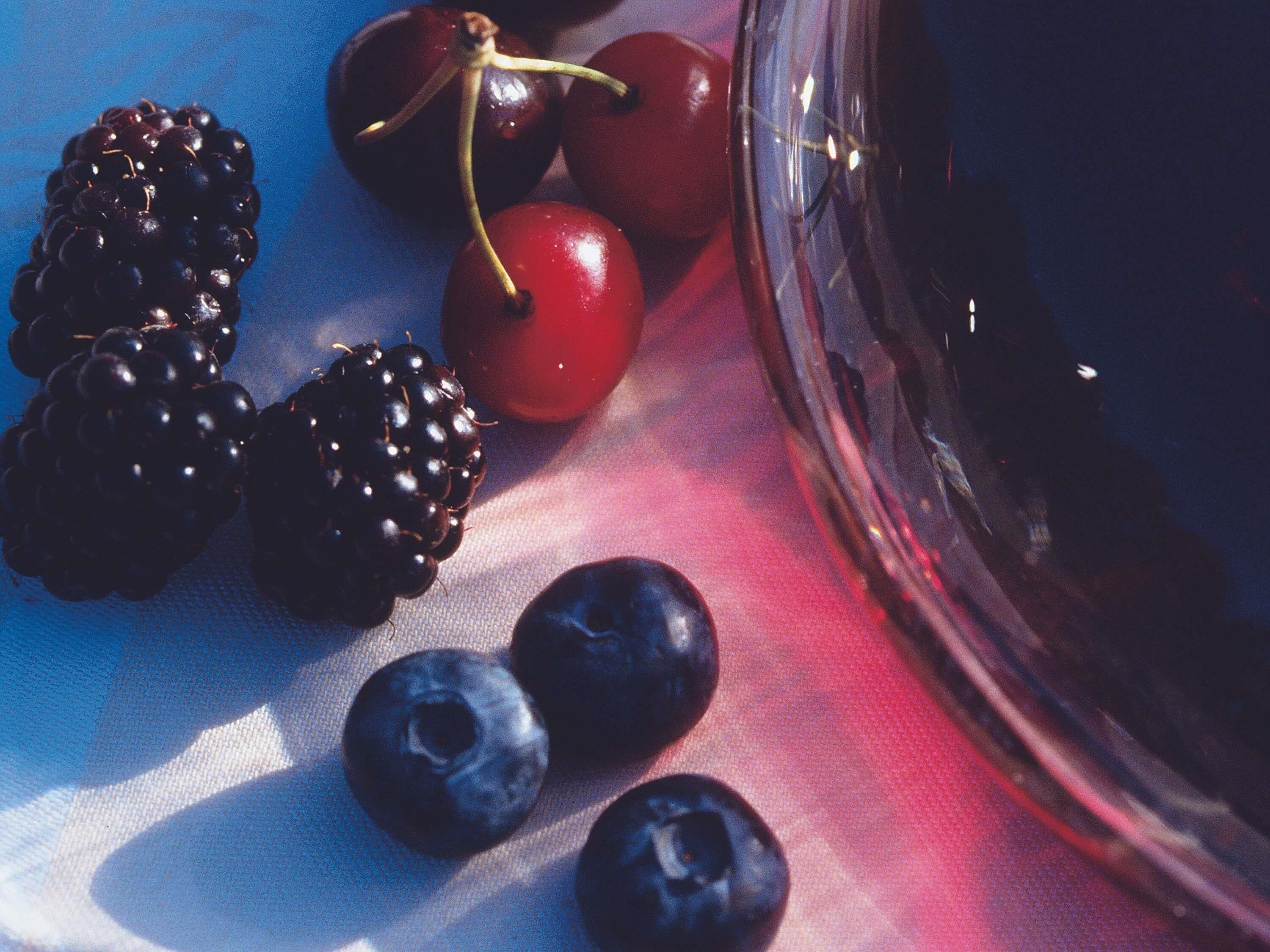 A table with blackberries, cherries, and blueberries.