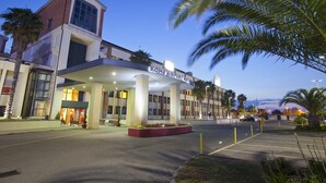 The Rome Airport Hotel with a modern design, featuring a prominent entrance and a parking area. - Mercure Rome Leonardo da Vinci Airport (Fiumicino)