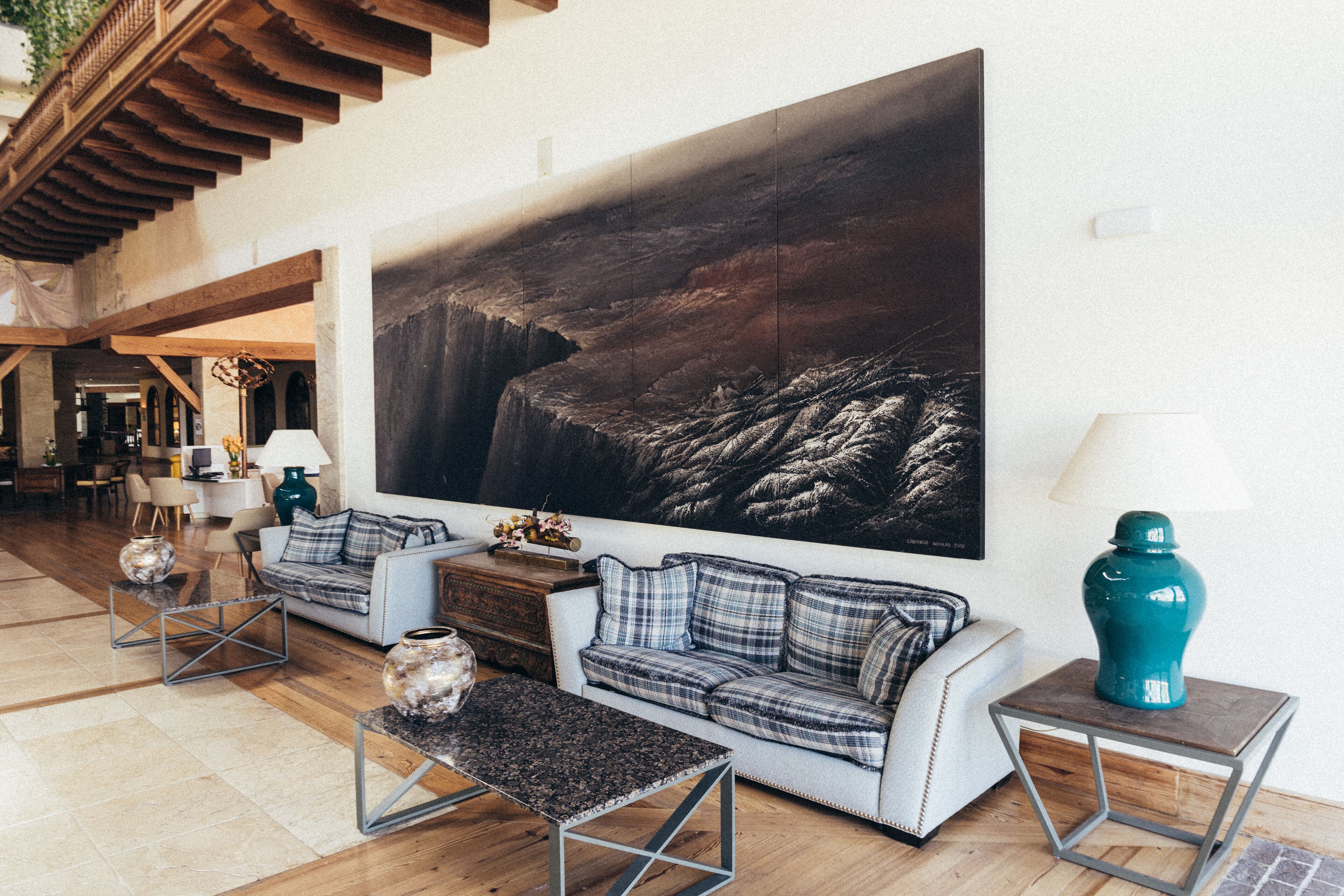 A spacious living area with a large sofa set, a coffee table, and a decorative vase.