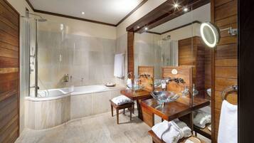 Een moderne badkamer met een glazen douchecabine, een vrijstaand bad en een wastafel met een grote spiegel en een ronde lamp.