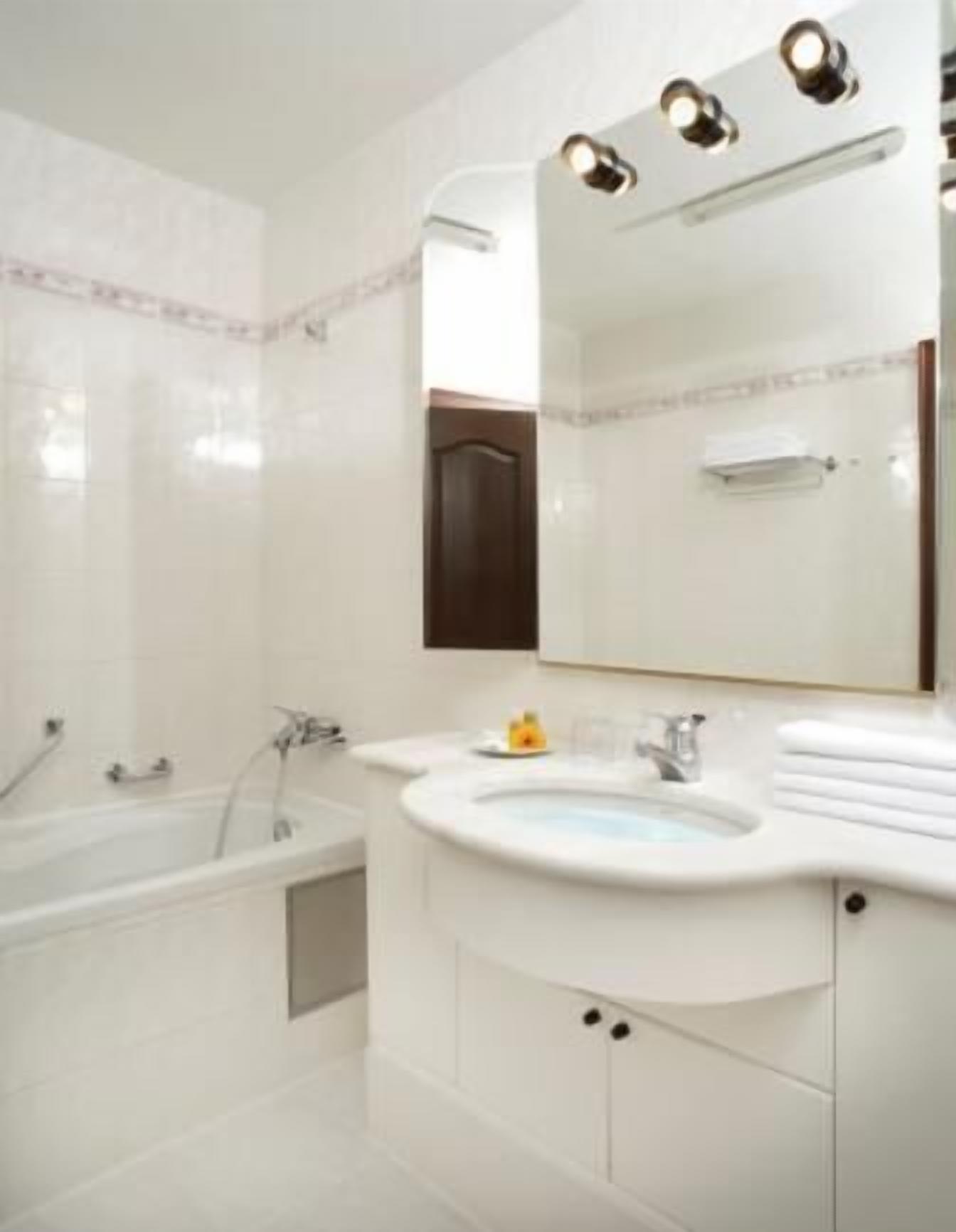 A modern bathroom with a bathtub, a sink, and a mirror.