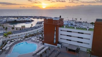 Una piscina al aire libre, sillones reclinables de piscina