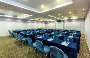 A conference room with multiple tables and chairs, equipped with water bottles and nameplates. - Leonardo Hotel Barcelona Gran Via (Barcelona)