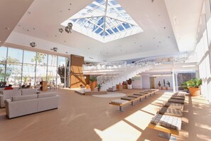 A spacious lobby with a high ceiling, a central staircase, and seating areas. - Hotel THB Lanzarote Beach (Teguise)