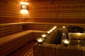 A wooden sauna with benches and lit candles. - Hotel Palcát Congress & Wellness Hotel (Tabor)