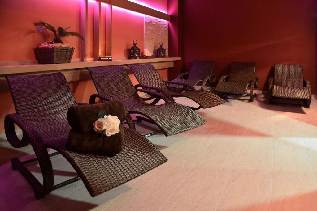 A spa area with wicker lounge chairs, a potted plant, and decorative lanterns.