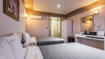 A hotel room with two beds, a desk, a mirror, and a door leading to another room.