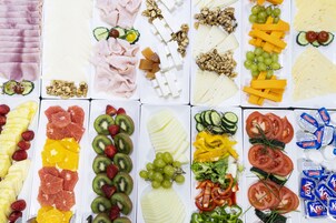 A variety of food items including fruits, cheeses, and meats arranged on a table.