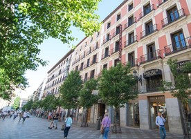 A multi-story hotel with balconies, a visible entrance, and a clear view of the street.
