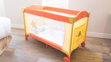 Cozy sleeping space for little ones, featuring a portable crib with mesh ventilation and easy-to-move wheels.