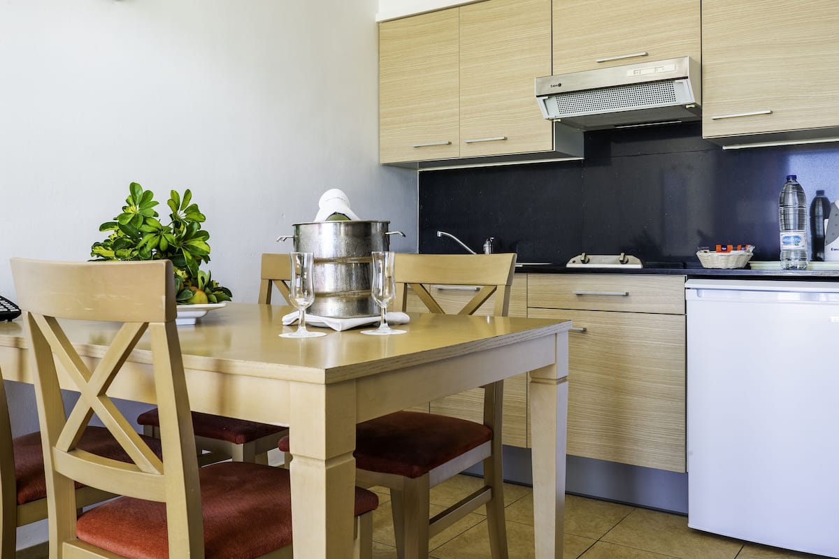 A modern kitchen with wooden cabinets, a stainless steel sink, and a white dishwasher.