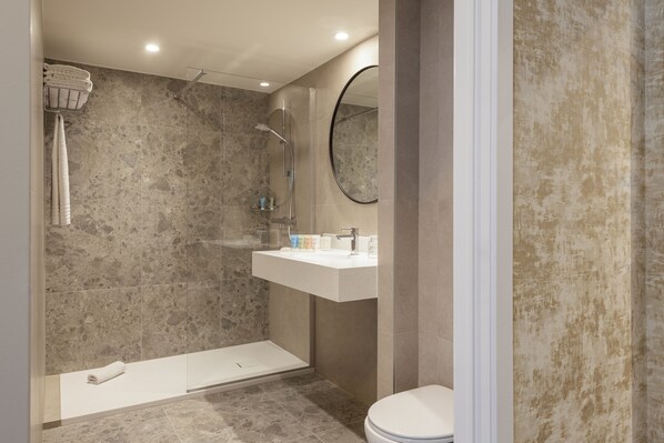Un baño moderno con ducha, inodoro y lavabo.