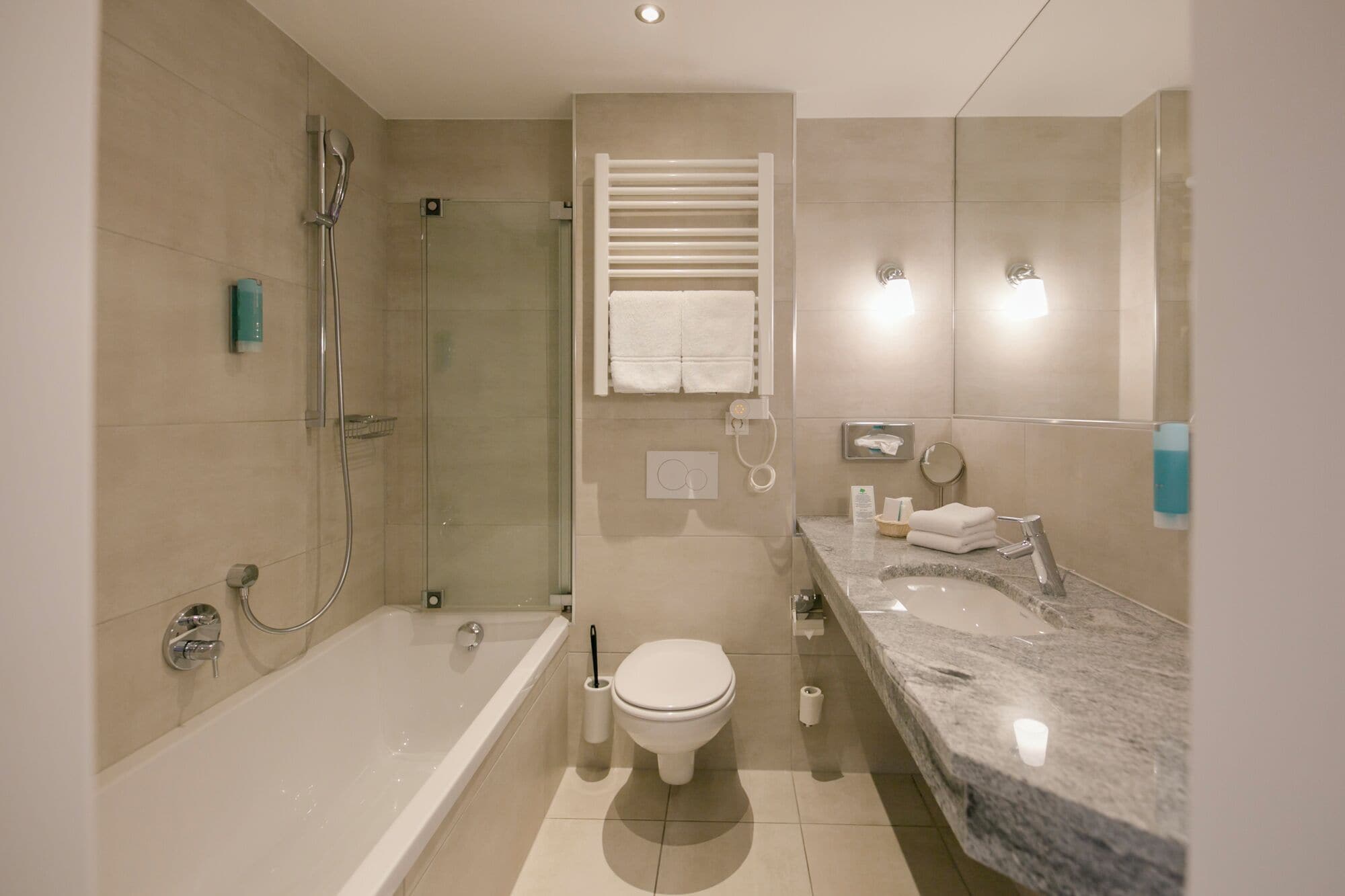 A modern bathroom with a bathtub, toilet, and a shower area.