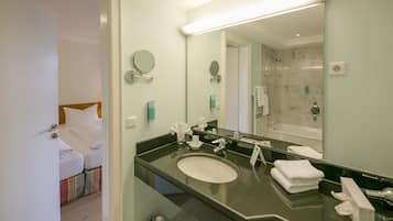 Een moderne badkamer met een grote spiegel, een wastafel en een douchehoek.