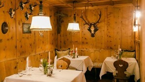 Un comedor acogedor con paredes de madera, adornos de asta y mesas dispuestas para comer.