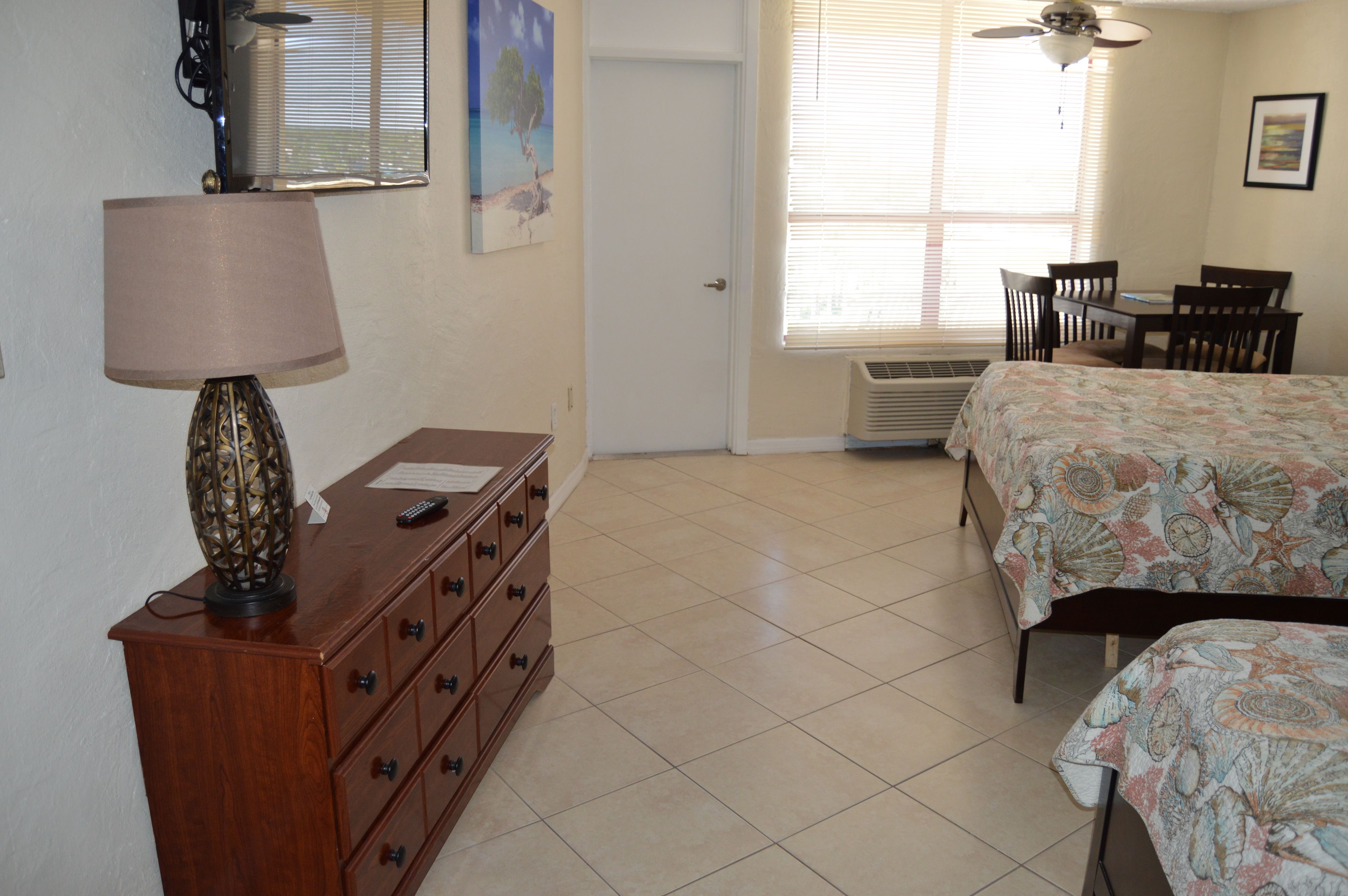 A bedroom with a bed, a dresser, a desk, and a chair.