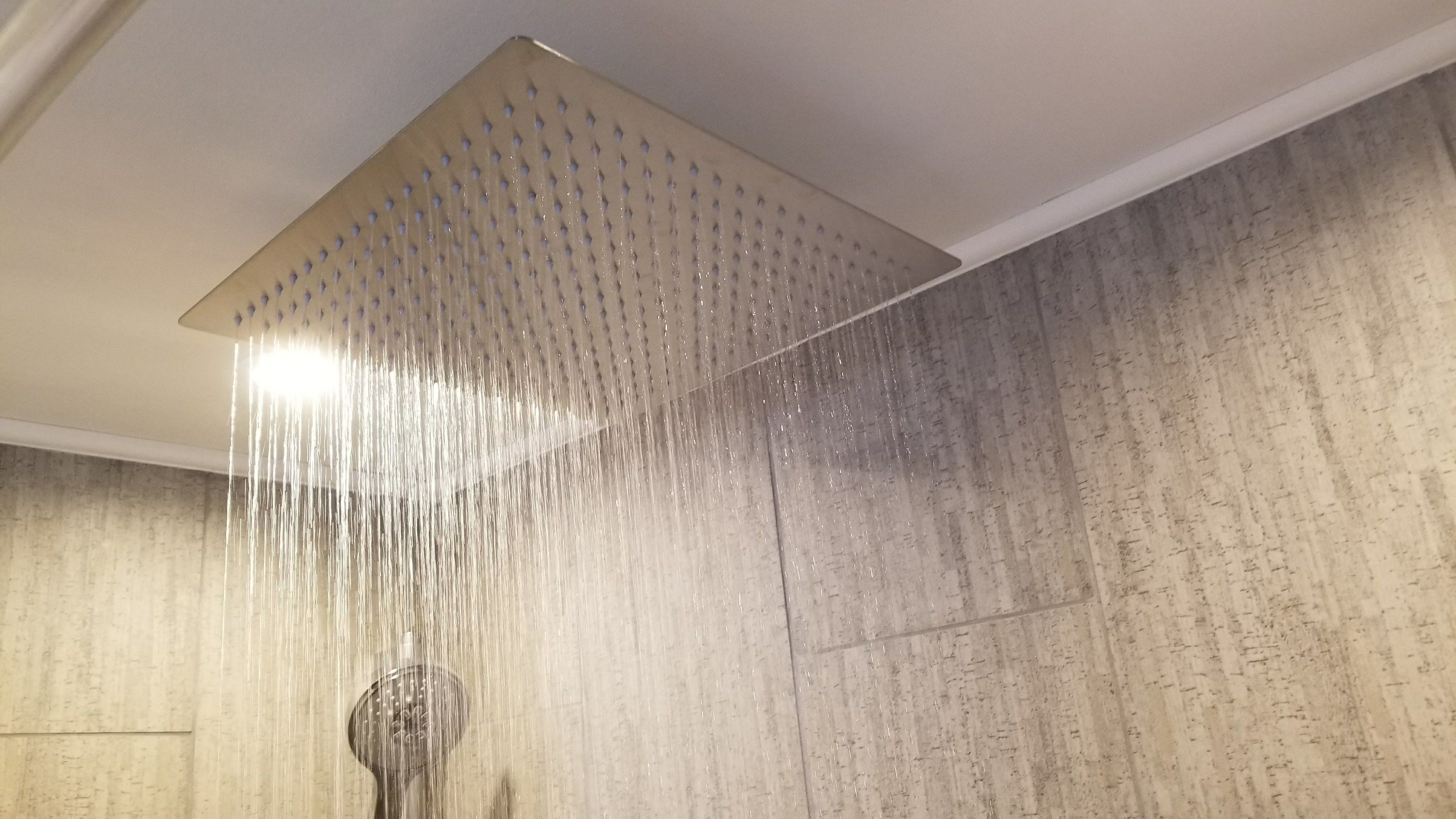 A shower with a square, perforated ceiling.