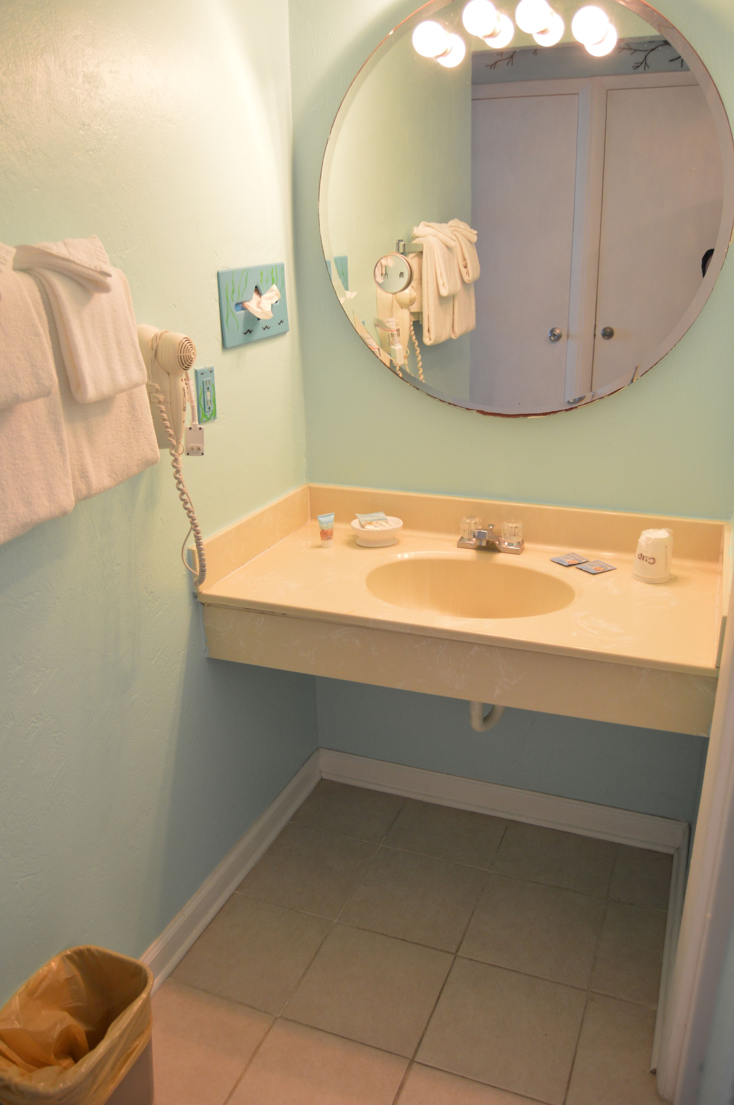 A bathroom with a sink, mirror, and a towel rack.