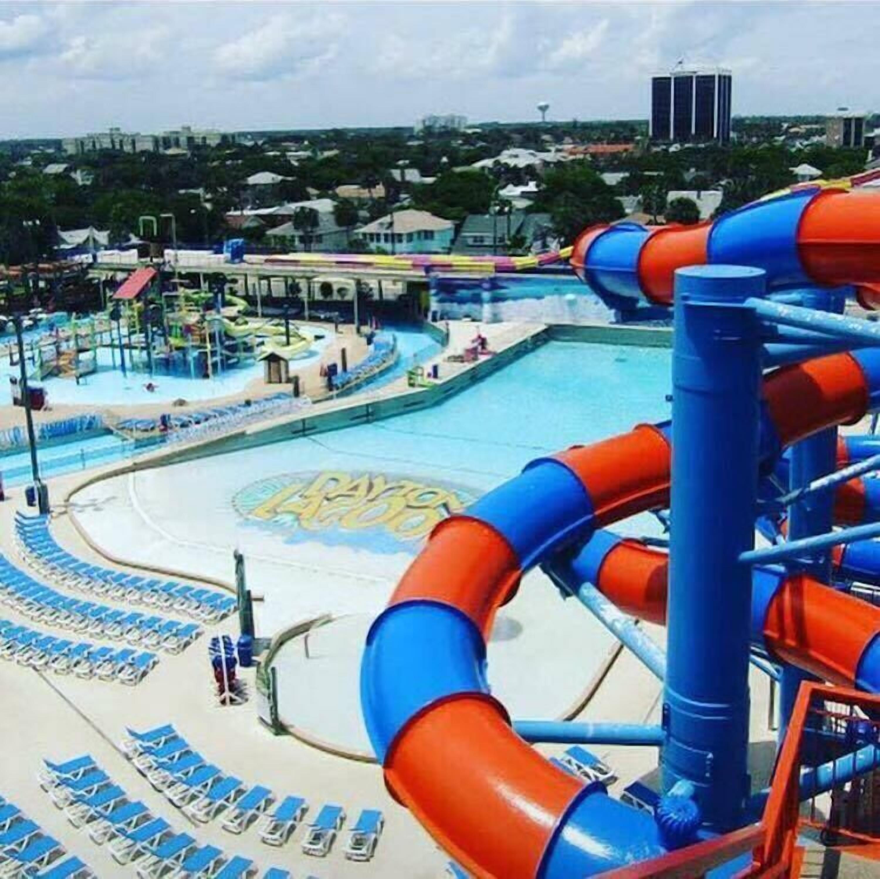 Ein Wasserpark mit großem Pool, Rutschen und Liegestühlen.