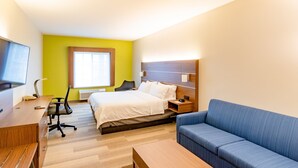 A hotel room with a bed, a desk, a chair, a sofa, a TV, and a window with blinds. - Holiday Inn Express Hereford by IHG (Hereford)
