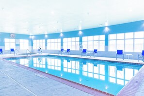 An indoor swimming pool with clear water, blue chairs, and a sunlit room with large windows. - Holiday Inn Express Hereford by IHG (Hereford)