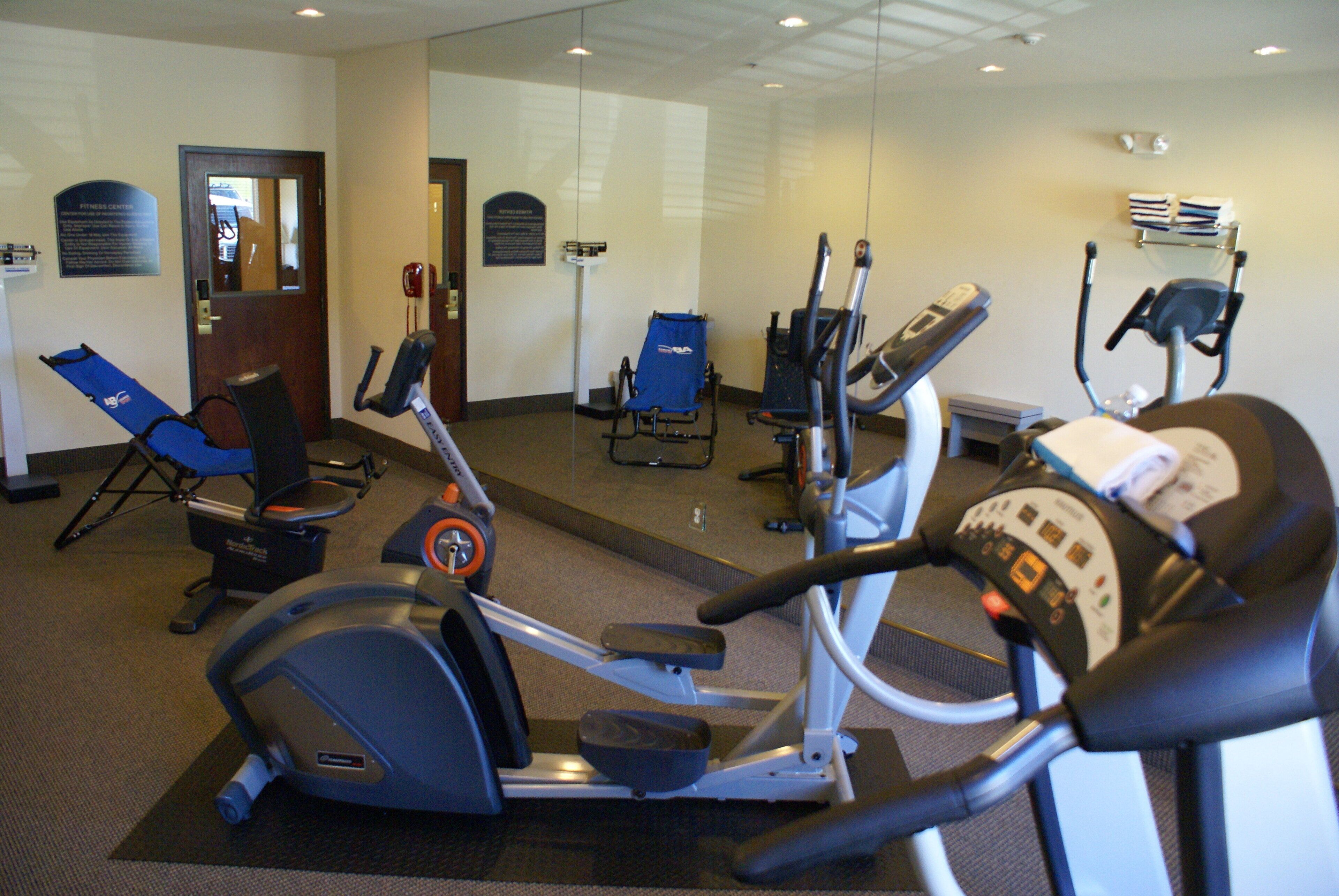 A fitness center with various exercise equipment including treadmills and stationary bikes.