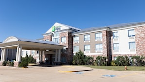A Holiday Inn Express hotel with a covered entrance, brick facade, and a parking lot with handicapped parking. - Holiday Inn Express Hotel & Suites Mountain Home by IHG (Mountain Home)